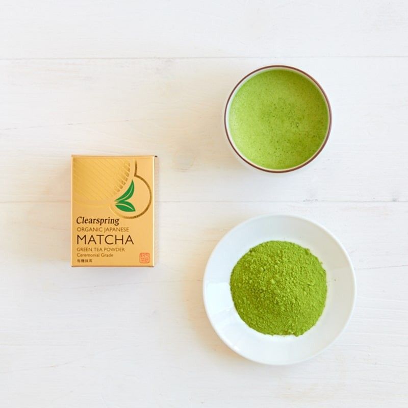 Ceai Verde Matcha Clearspring 30g, pudră verde, cutie aurie, farfurie albă cu pudră, bol matcha.