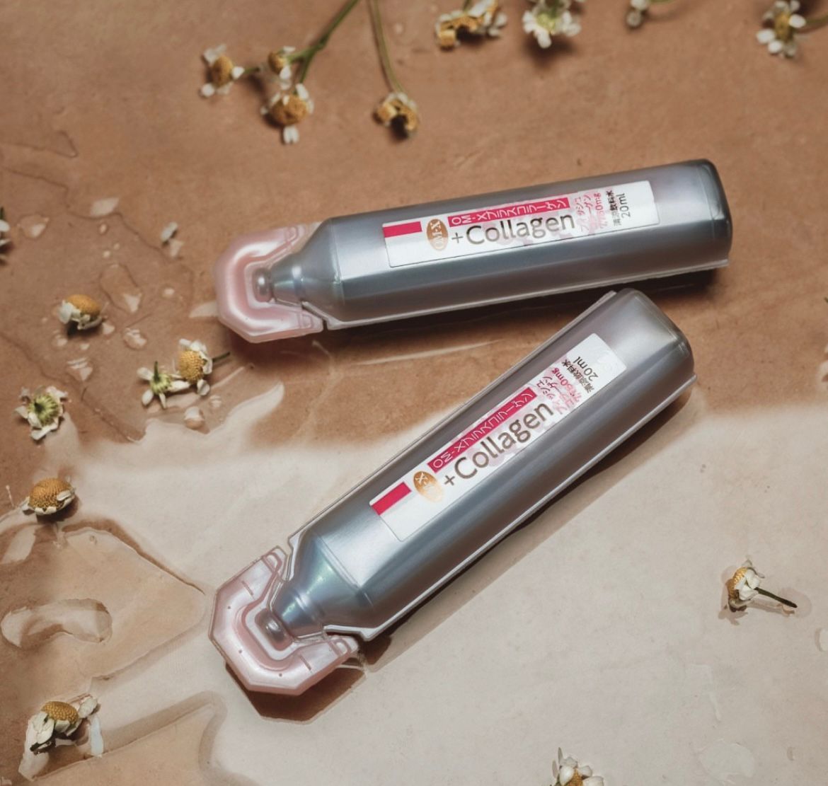 Fiole Dr.Ohhira Anti Age Colagen OM-X pe fundal maro cu flori albe uscate.