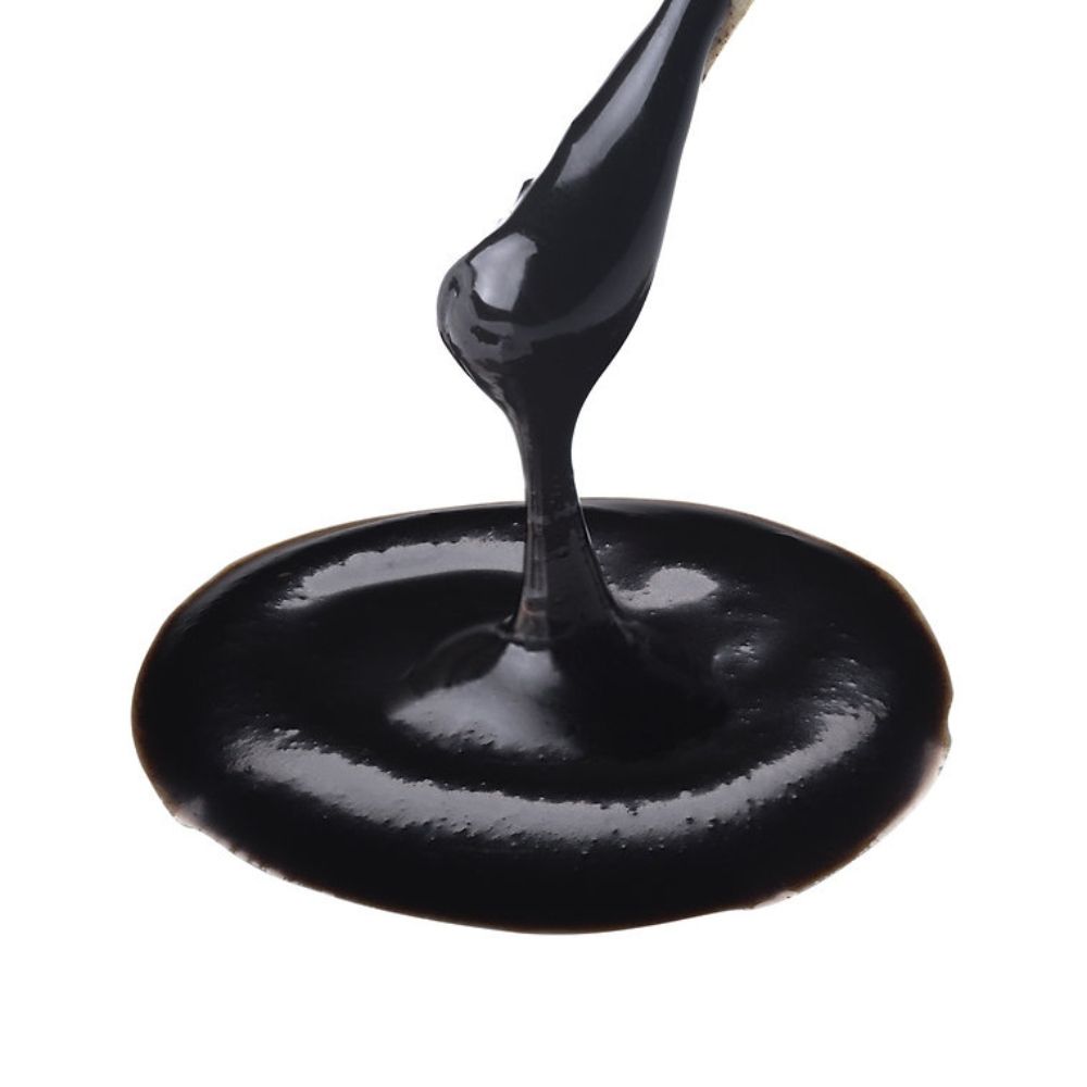 Extract negru fermentat Dr.Ohhira® cu textură vâscoasă, compoziție densă și luciu intens.