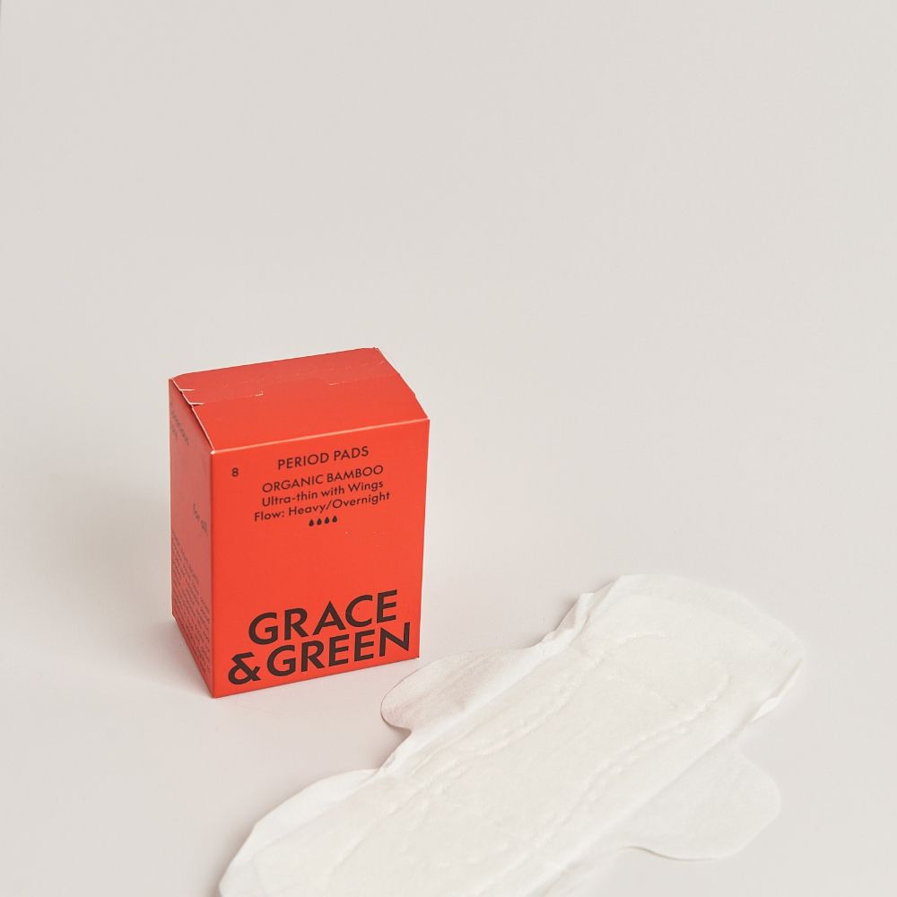 Cutie roșie absorbante bambus organic noapte, lângă un absorbant alb cu aripioare.