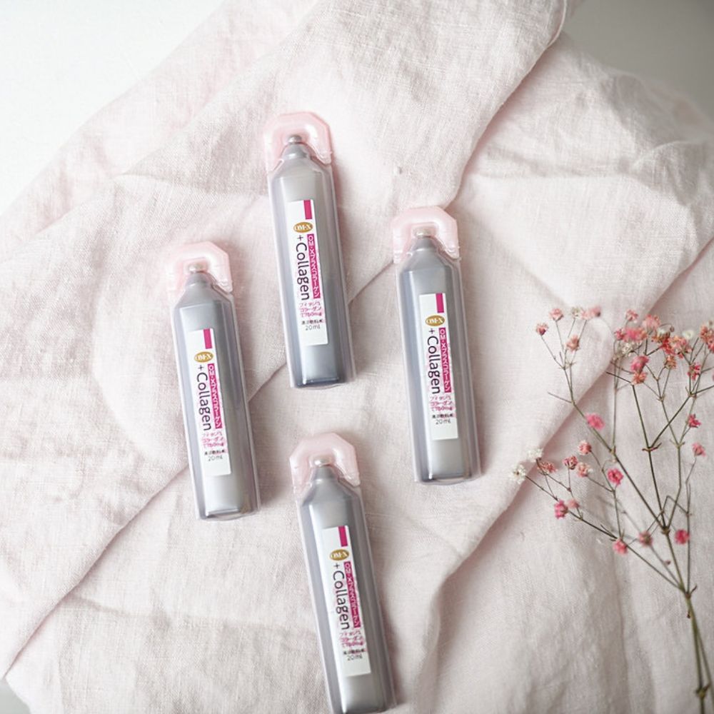 Fiole Dr.Ohhira® Colagen, argintii, pe material roz deschis, alături de flori uscate.