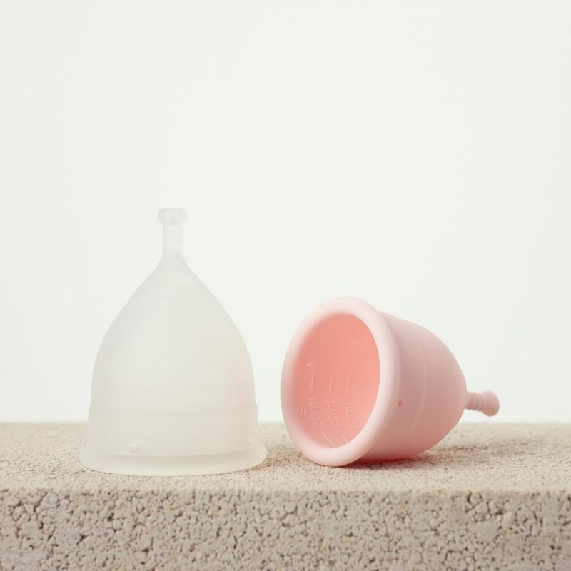 Cupe menstruale Grace and Green, mărimea A și B, textură mătase, culori roz și alb translucid.