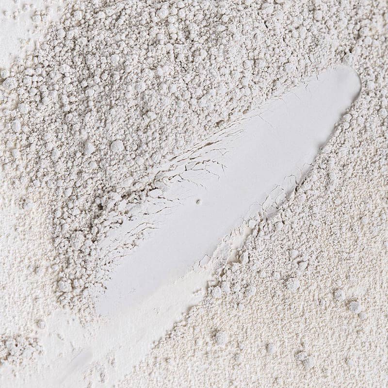 Pudră matifiantă organică pentru fixare machiaj, textura fină, albă, detalii granulate.