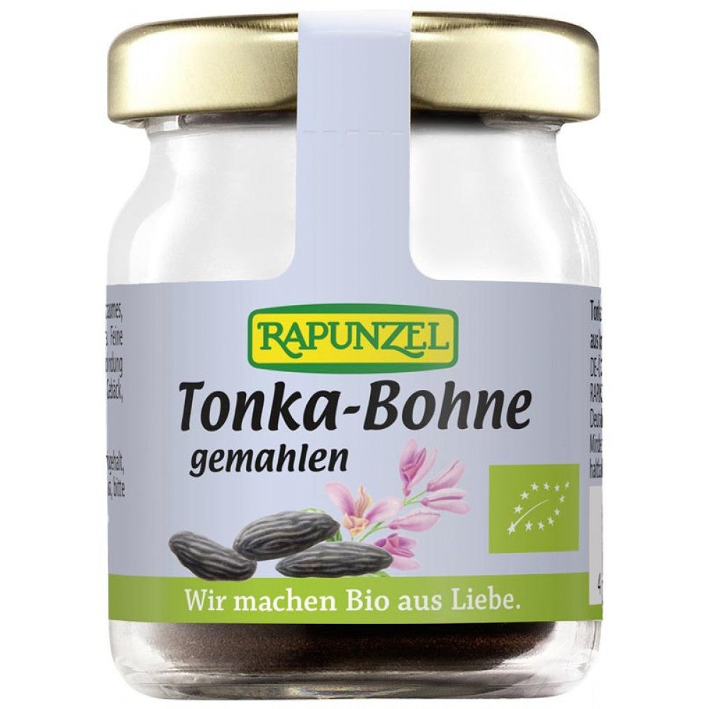 Boabe Tonka macinate 10g Rapunzel, borcan sticlă cu capac metalic aurit, etichetă albastră cu detalii verzi.