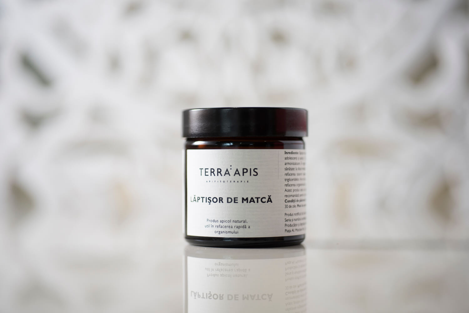 Borcan maro cu lăptișor de matcă Terra Apis, capac negru, etichetă albă text negru.